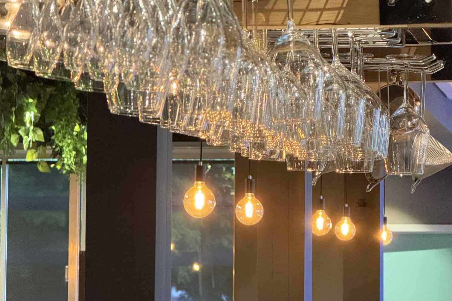 Warm bar lighting, hanging glassware, relaxed mood at The Hill