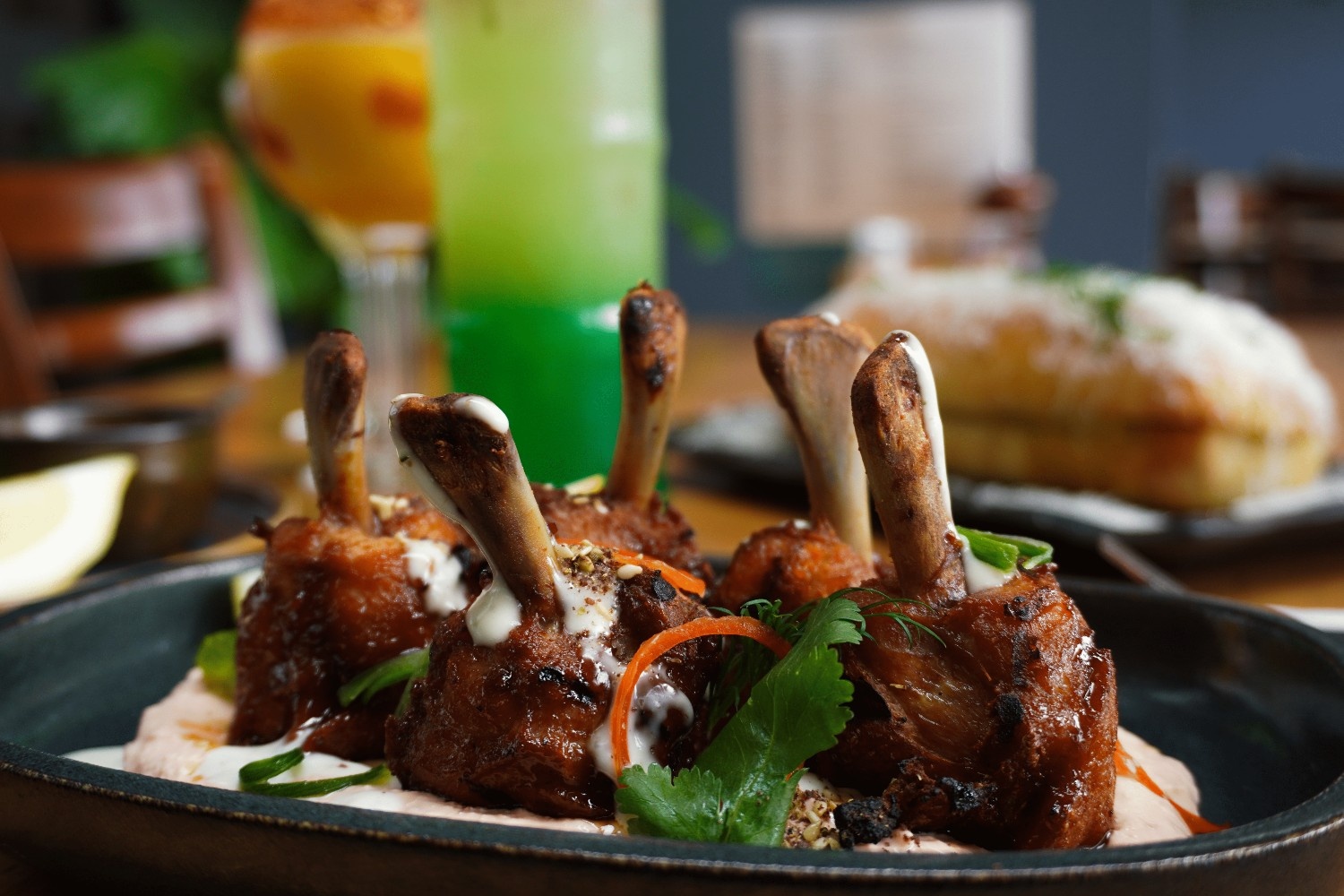 Crispy chicken lollipops on whipped dip with herbs