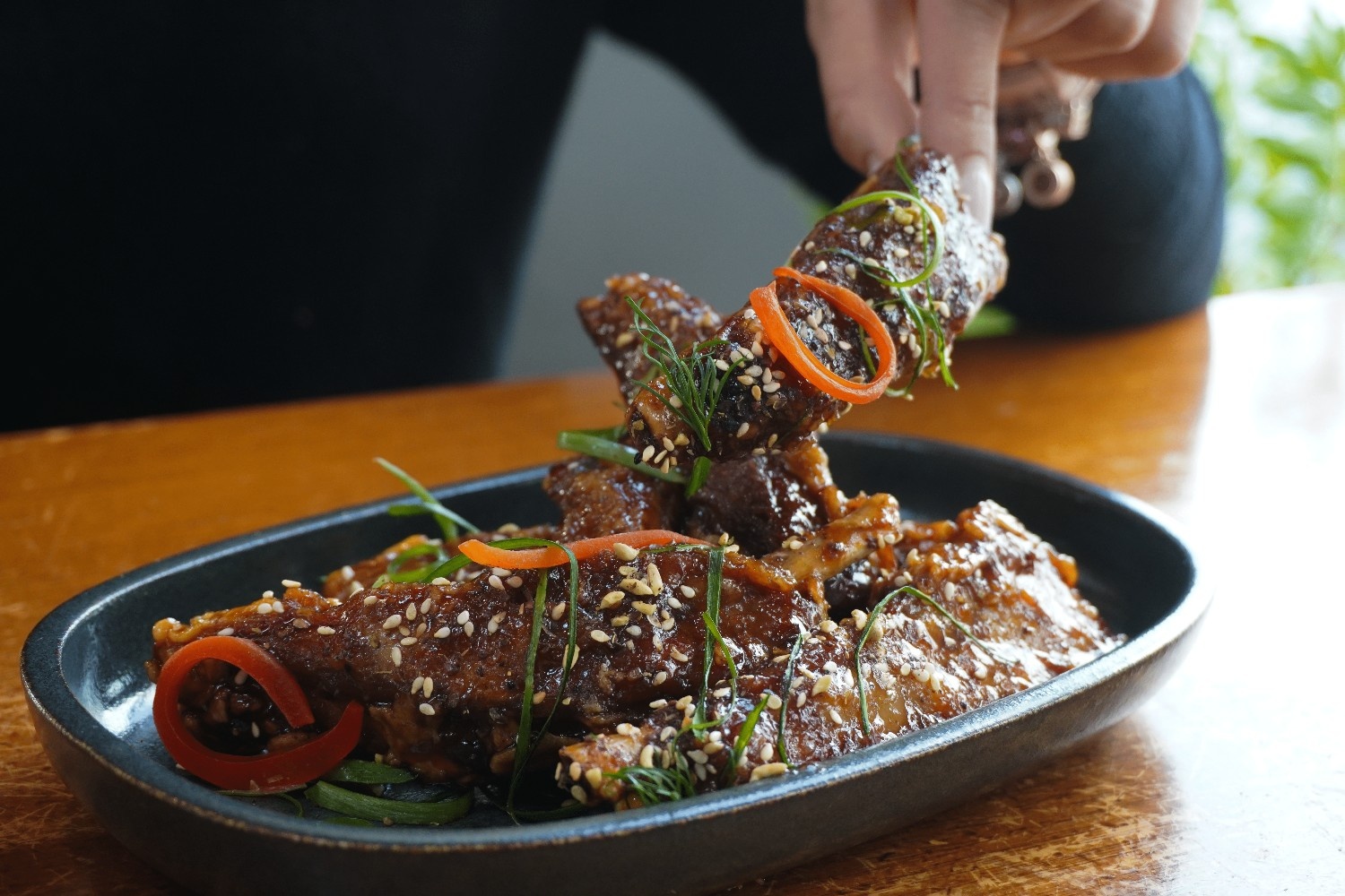 Sticky rib bites tossed with sesame, chilli and spring onion